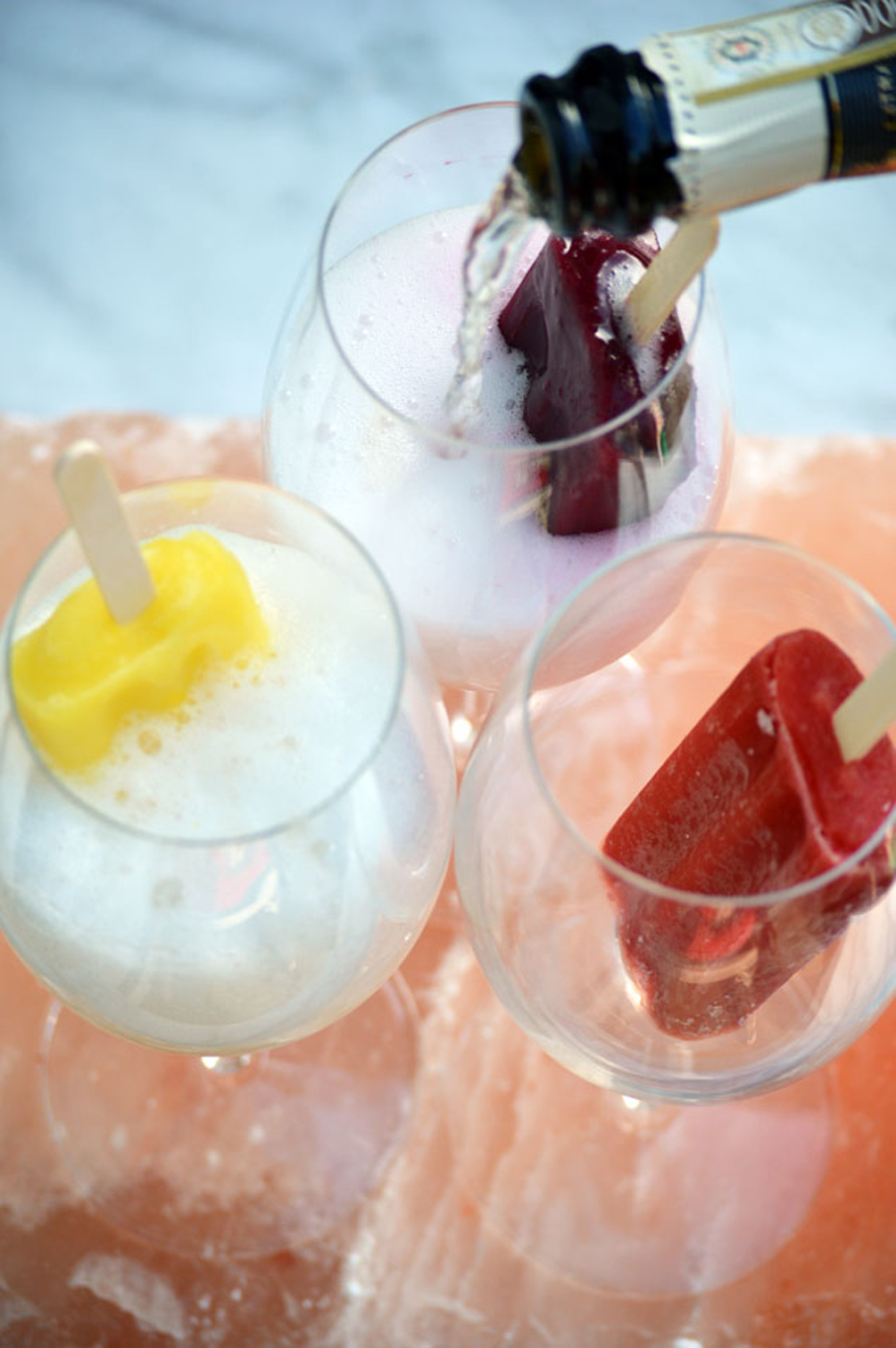 champagne poured over fruit popsicles