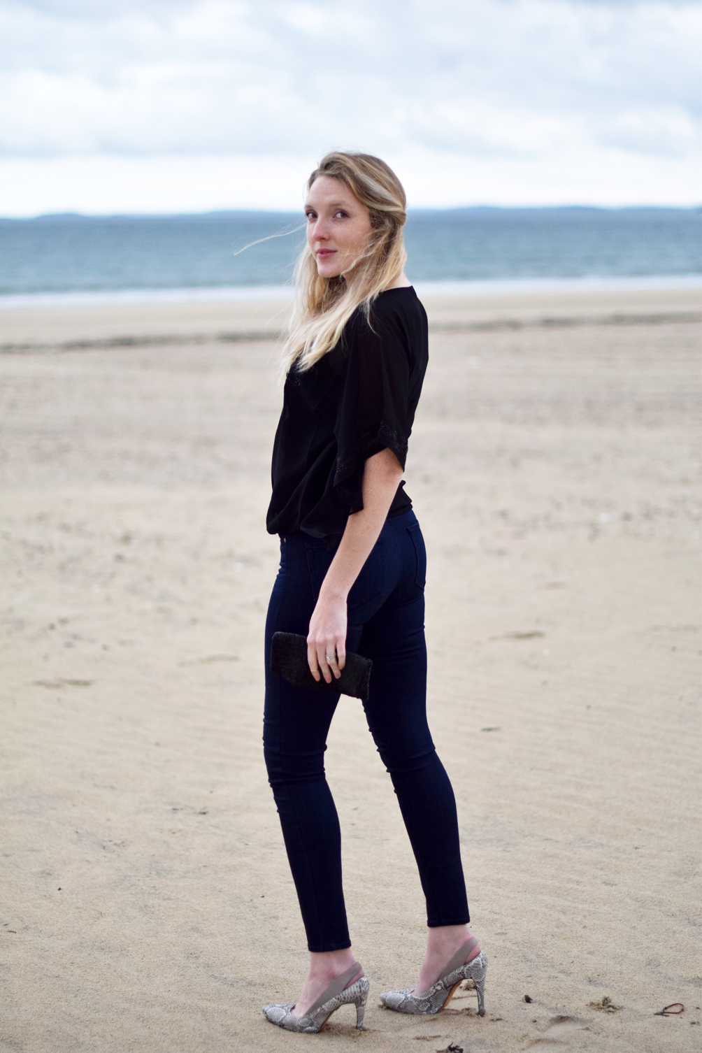 spring date night style with a black blouse and dark denim - one brass fox