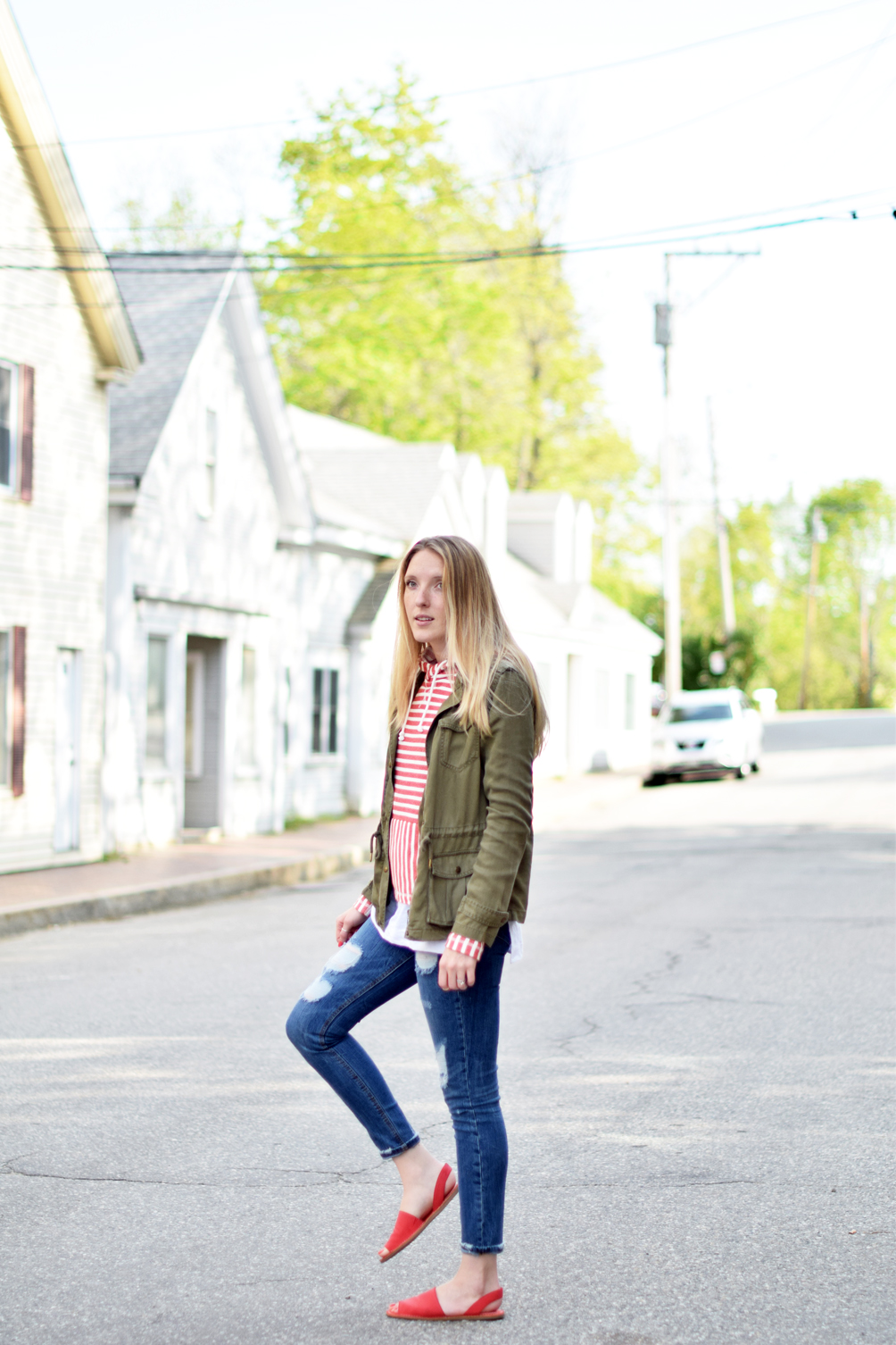 spring style, nautical striped hoodie with destructed denim, red slide sandals, and an army green jacket, leslie musser of one brass fox