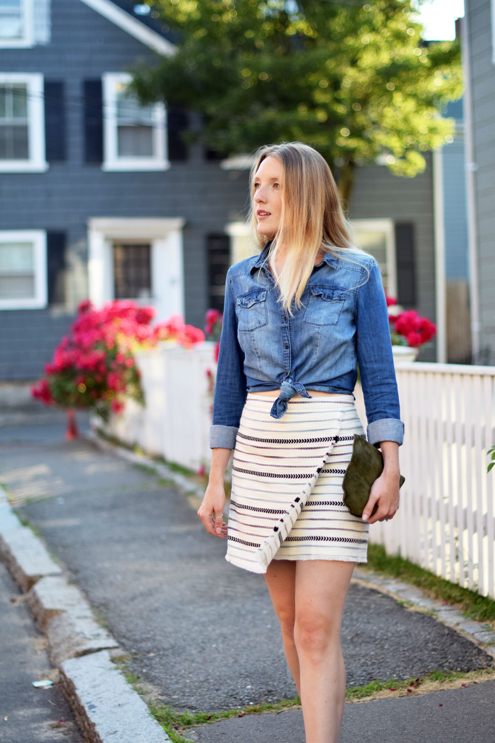 fashion blogger Leslie Musser of one brass fox wears a summer date night look of this chambray shirt, striped fringe wrap skirt, and suede mules
