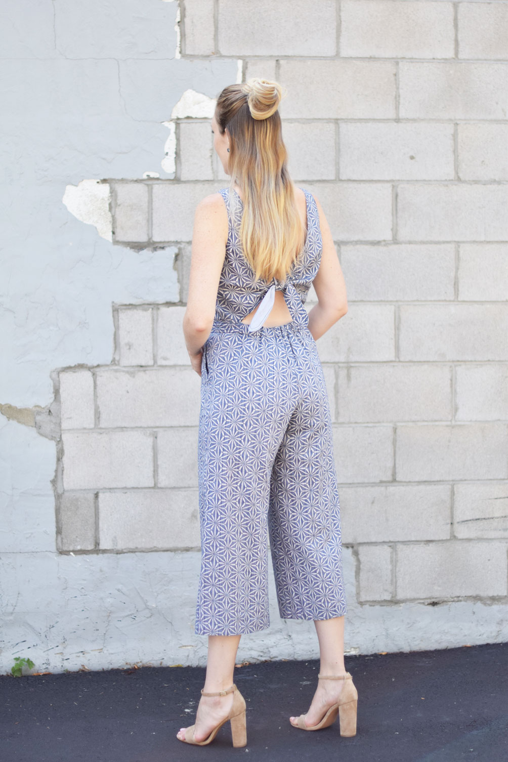 anthropologie tie back jumpsuit with calf hair clutch and block heel sandals on fashion blogger Leslie Musser, one brass fox