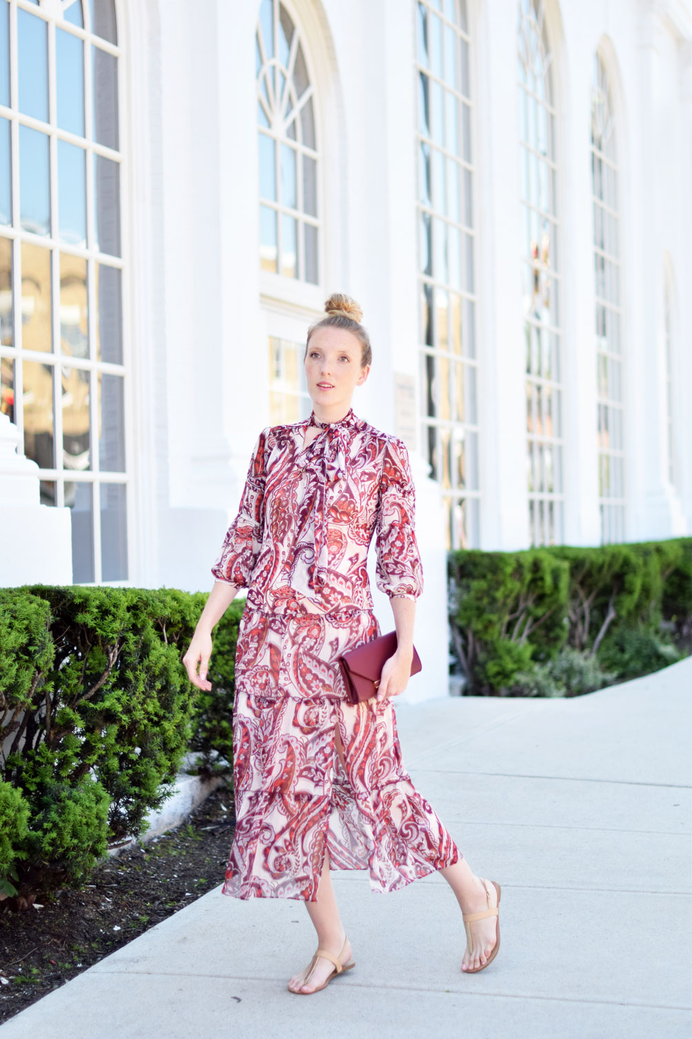 tie neck peasant midi dress with an oxblood clutch and simply top knot on Leslie Musser of one brass fox