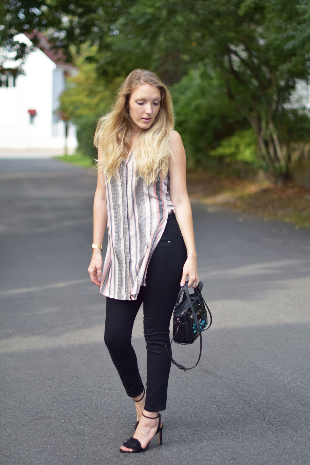 Leslie Musser wears a sleeveless tunic top with black skinny jeans and a butterfly embellished Coach bag on one brass fox