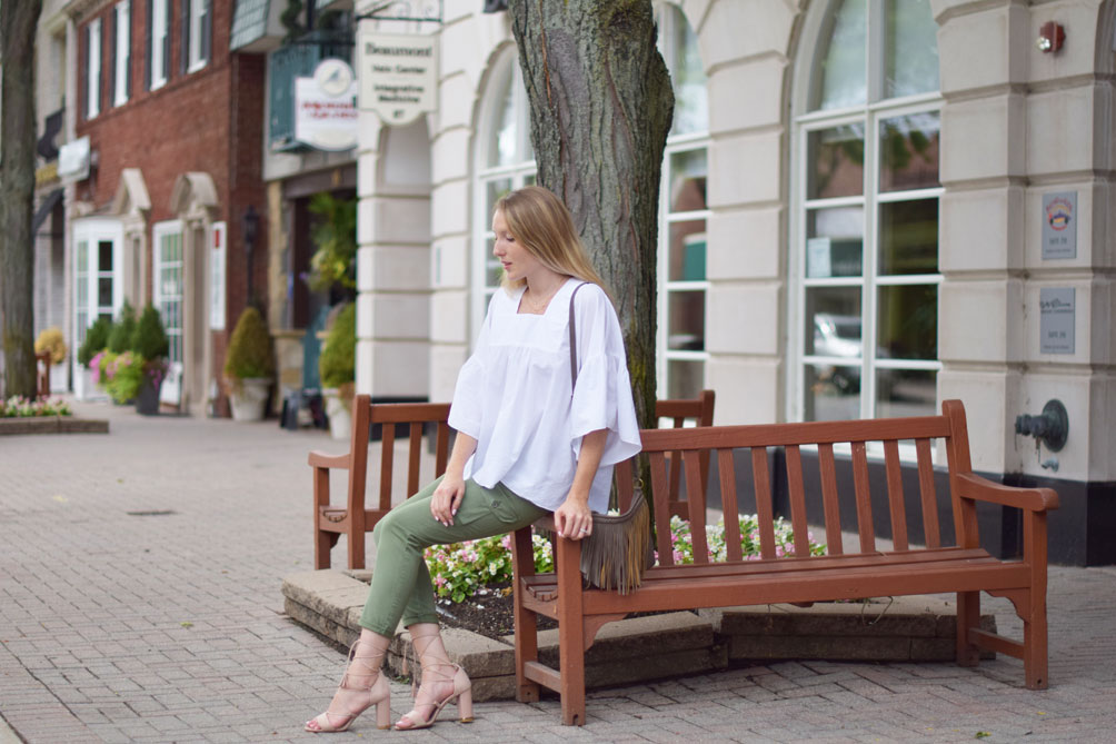 Leslie Musser wears utility cargo pants with lace up sandals and a fringe crossbody bag on one brass fox