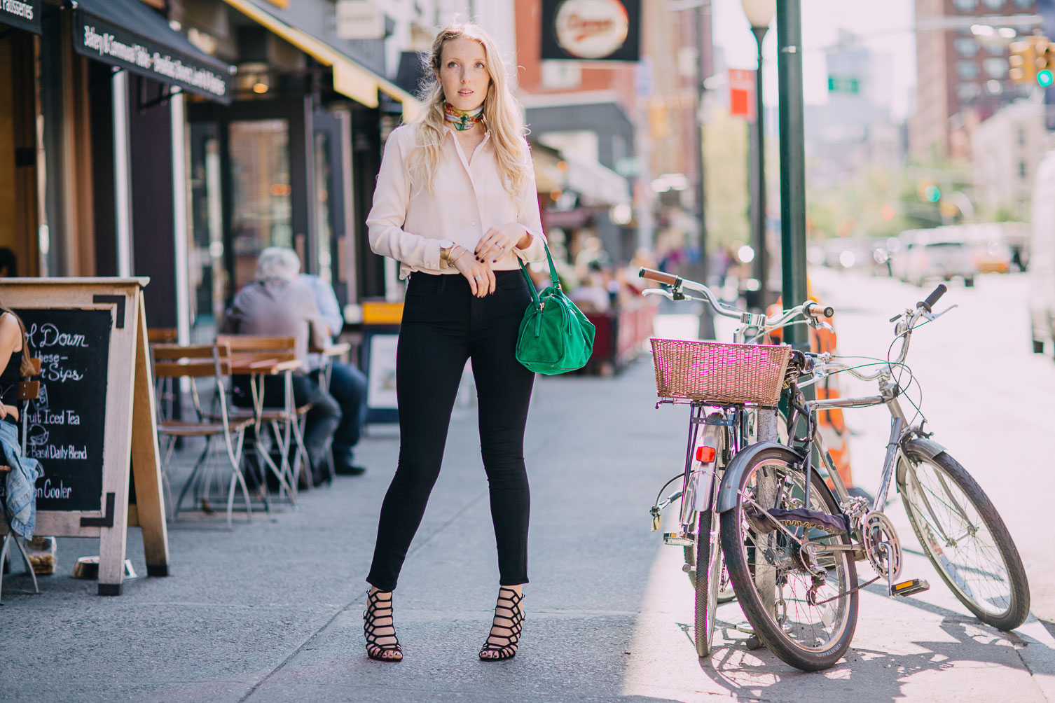 rose quartz silk blouse with jet black skinny jeans and an emerald bag on Leslie Musser one brass fox