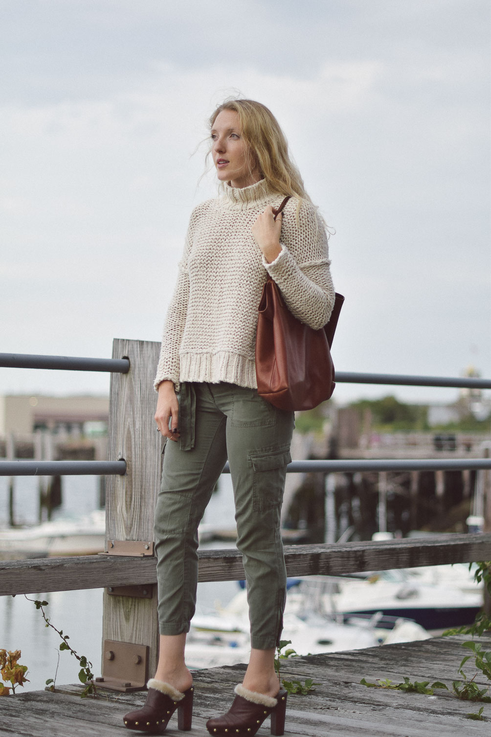 Free People chunky knit sweater with AG cargo pants and faux fur clogs on Leslie Musser one brass fox