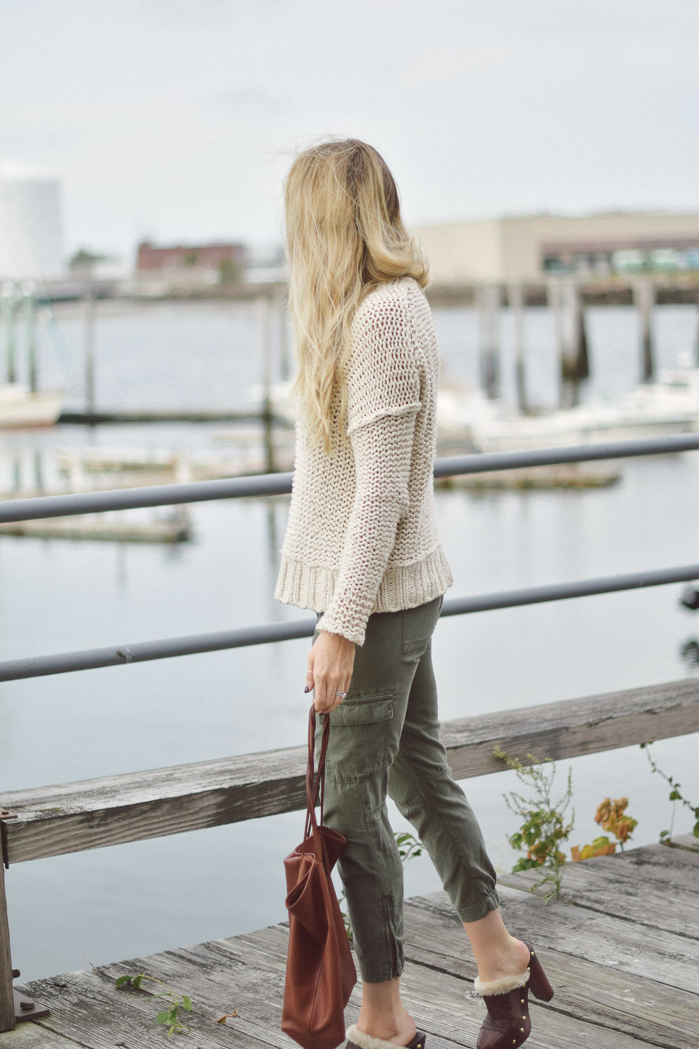 Free People chunky knit sweater with AG cargo pants and faux fur clogs on Leslie Musser one brass fox