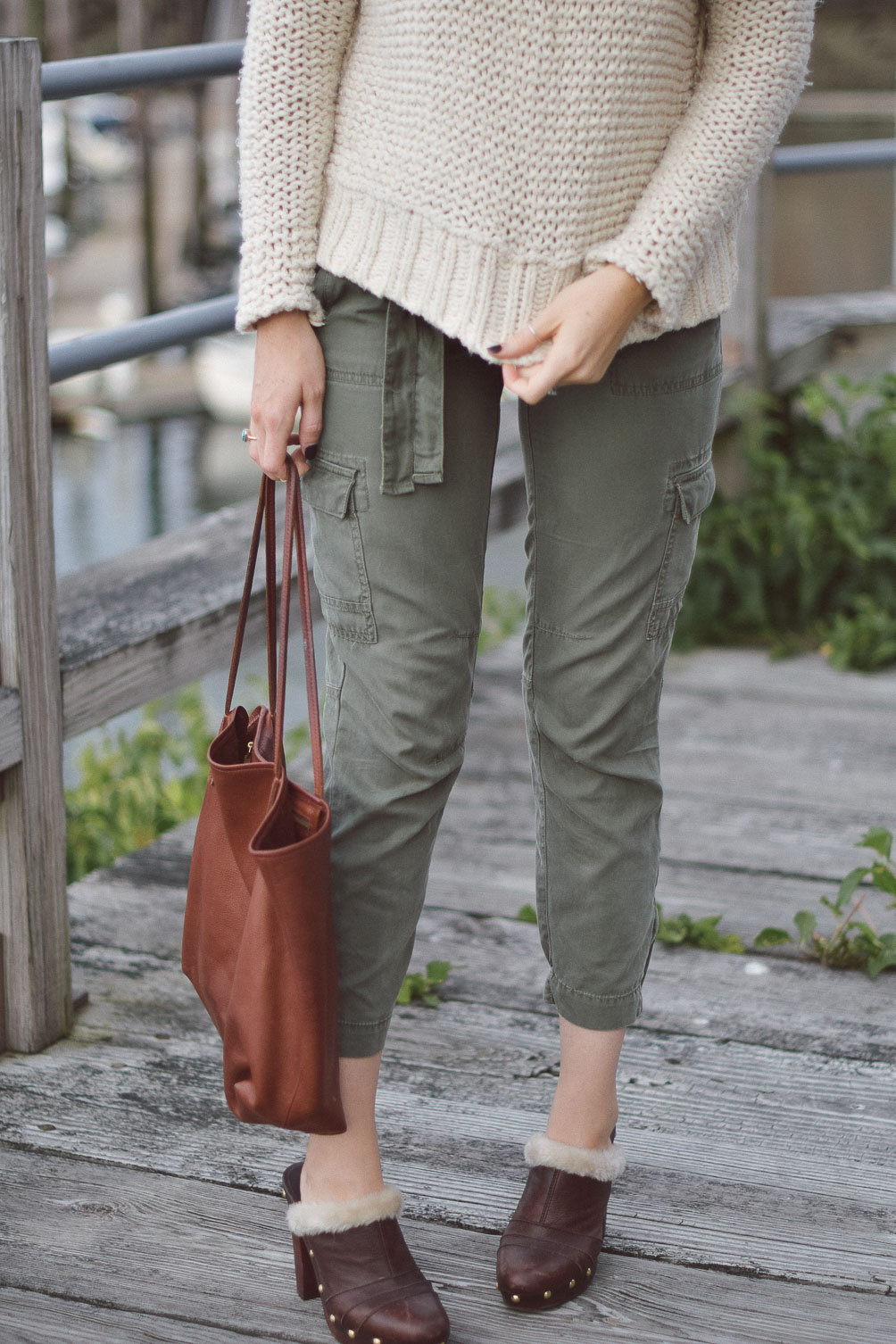 Free People chunky knit sweater with AG cargo pants and faux fur clogs on Leslie Musser one brass fox