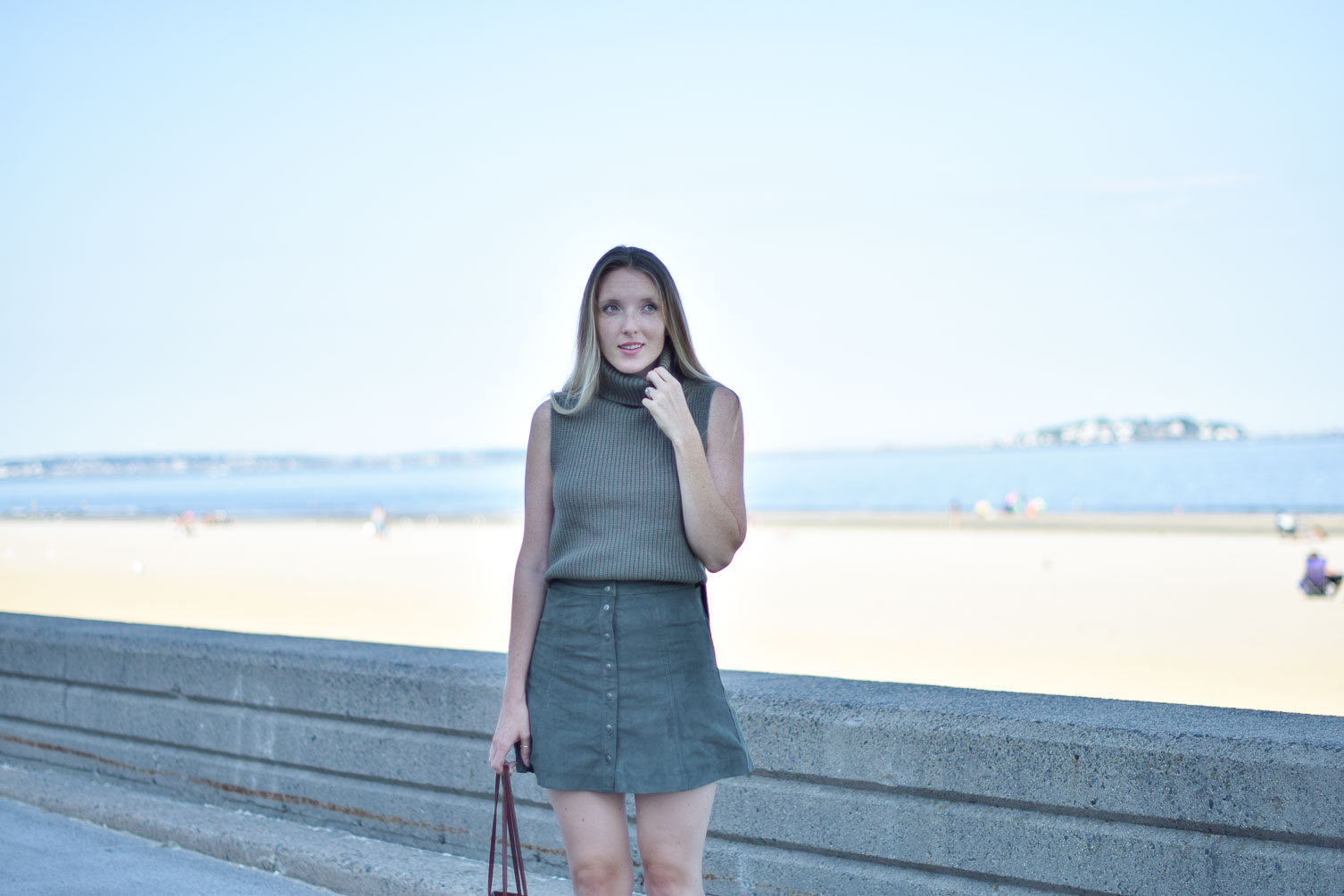 styling a suede skirt for fall with a cozy knit vest and leather tote bag on Leslie Musser of one brass fox