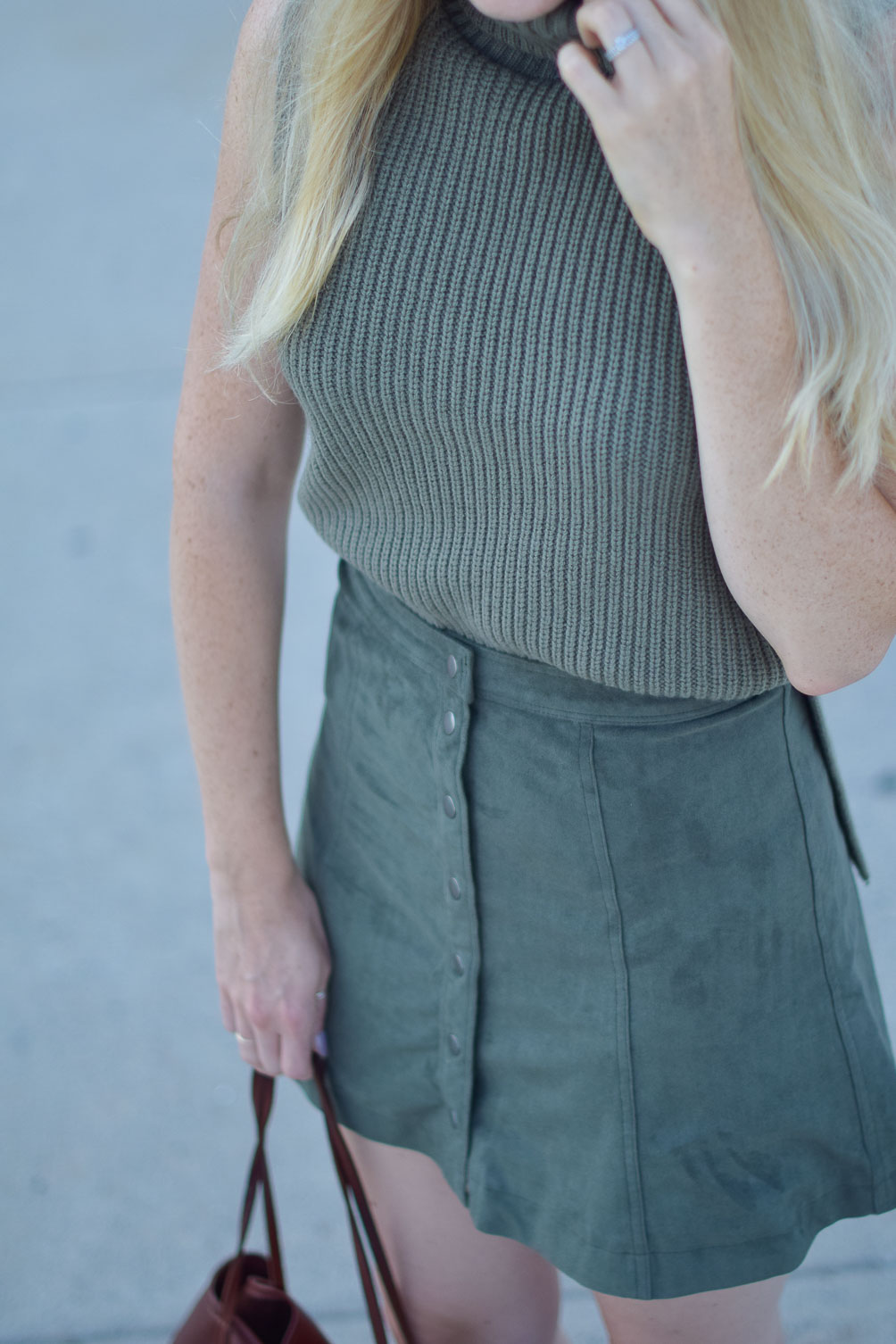 styling a suede skirt for fall with a cozy knit vest and leather tote bag on Leslie Musser of one brass fox