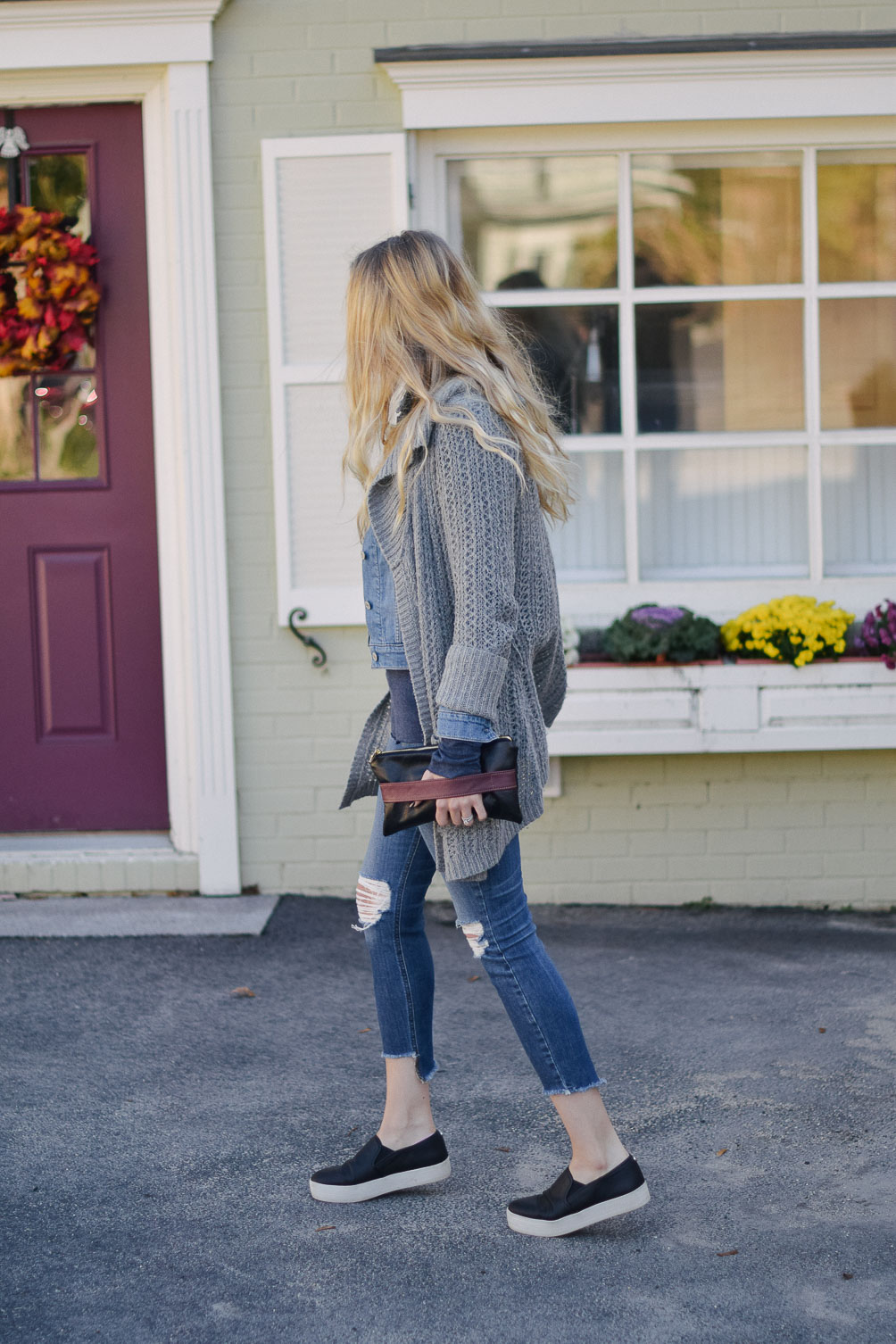 Leslie Musser styling an open knit cardigan with denim jacket and distressed jeans for fall style on one brass fox