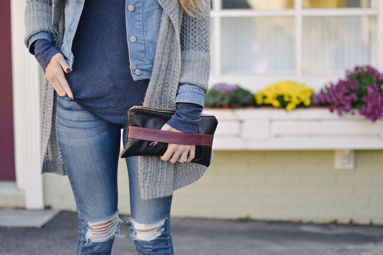 Leslie Musser styling an open knit cardigan with denim jacket and distressed jeans for fall style on one brass fox