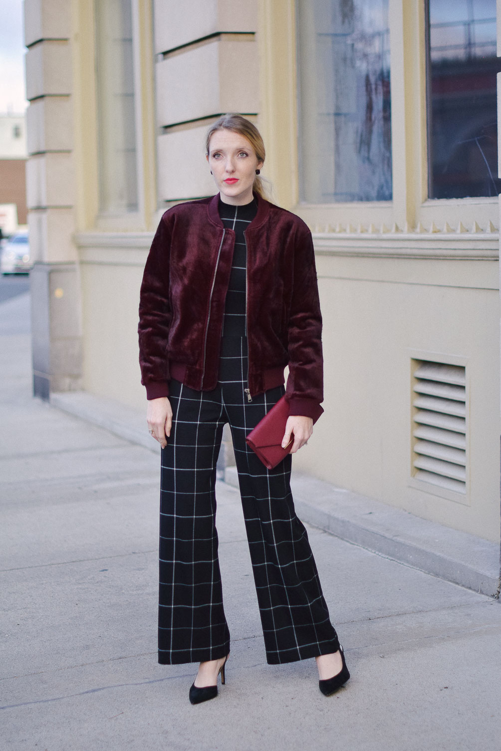styling a faux fur bomber jacket with check jumpsuit for an alternative holiday party outfit