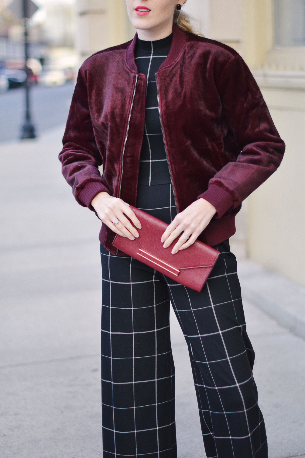 styling a faux fur bomber jacket with check jumpsuit for an alternative holiday party outfit