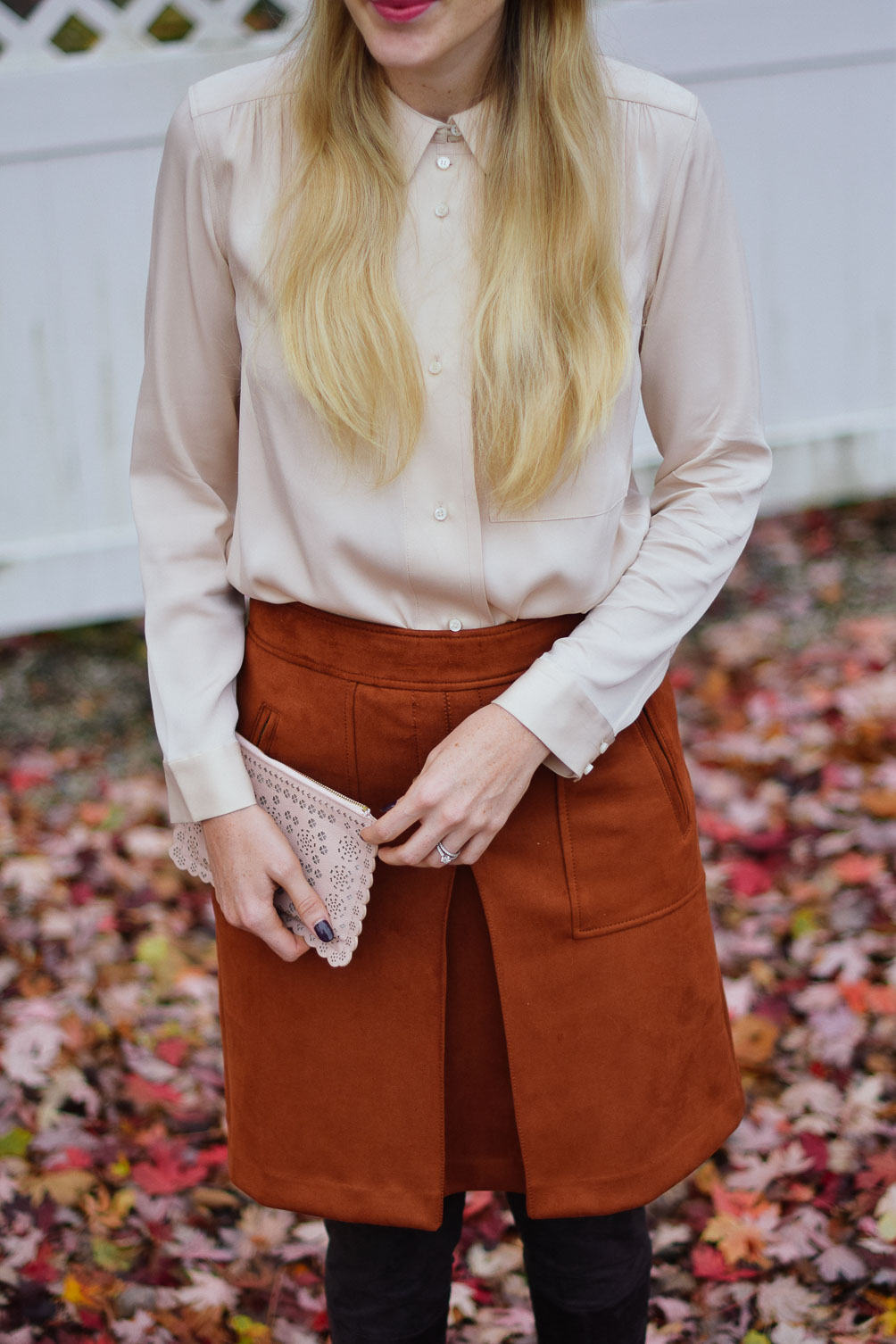 Leslie Musser wearing a rust suede skirt with blush blouse and over the knee boots on one brass fox