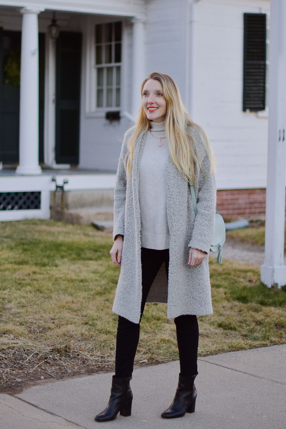 styling a coatigan layered over black skinny jeans and turtleneck sweater with black leather booties