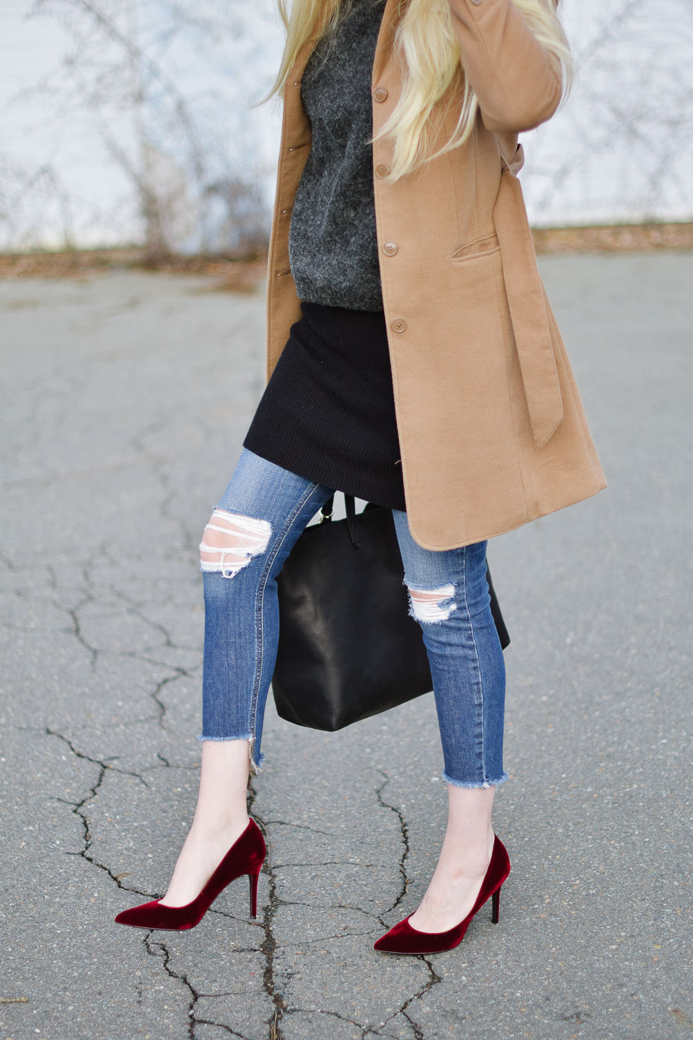 styling a layered winter outfit with this camel coat, chunky sweater, distressed denim, and velvet pumps