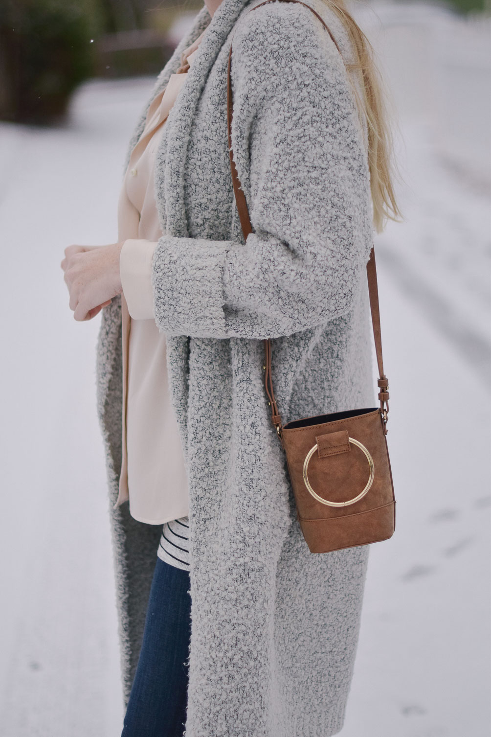 styling a faux suede mini bag with raw edge maternity jeans and an oversized cardigan