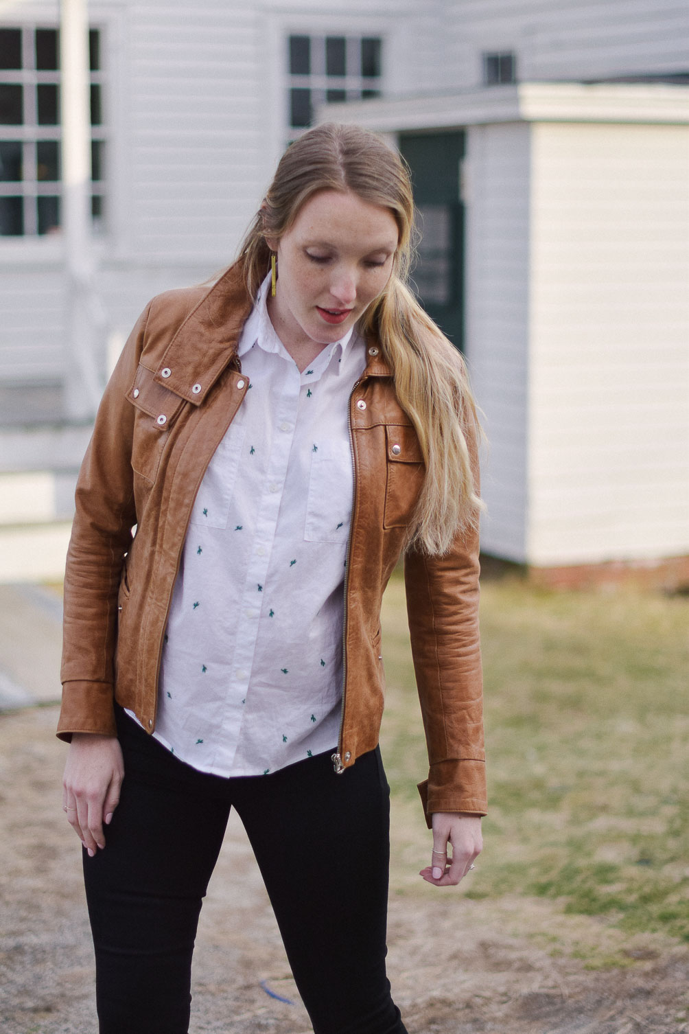 styling easy maternity outfit with cactus print top, skinny jeans, and tan leather jacket