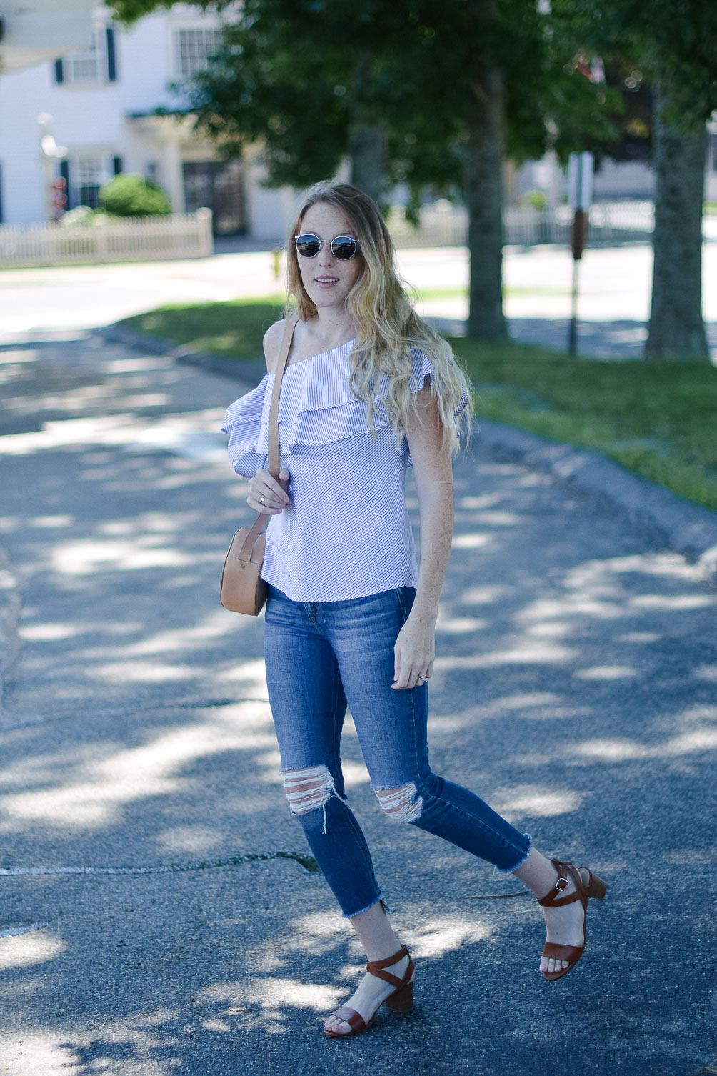 styling a summer outfit with this one shoulder ruffle top and distressed skinny jeans