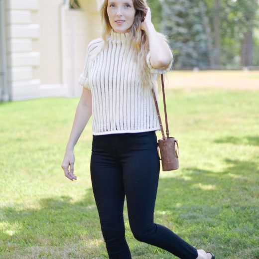 Leslie Musser styling a short sleeve sweater with black skinny jeans and leather mules for transitional fall style