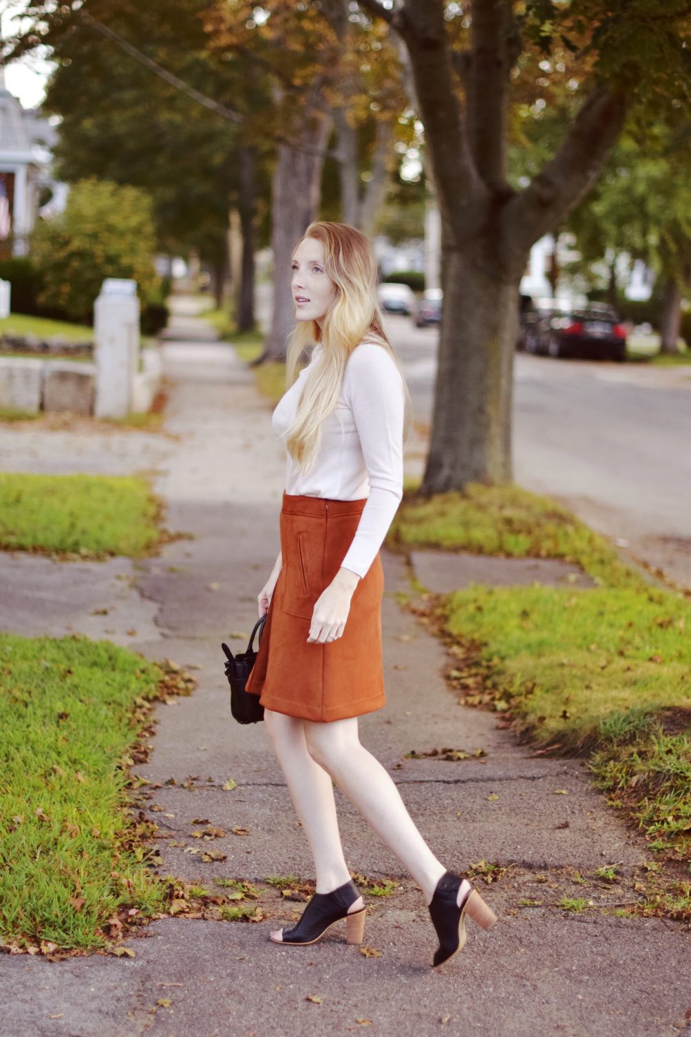 suede rust skirt on leslie musser with Club Monaco pink embroidered sweater and Coach appliqué bag for fall style outfit