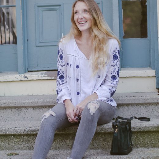 fashion blogger Leslie Musser styling the best bohemian tops for fall with gray denim, printed loafers, and a suede bucket bag