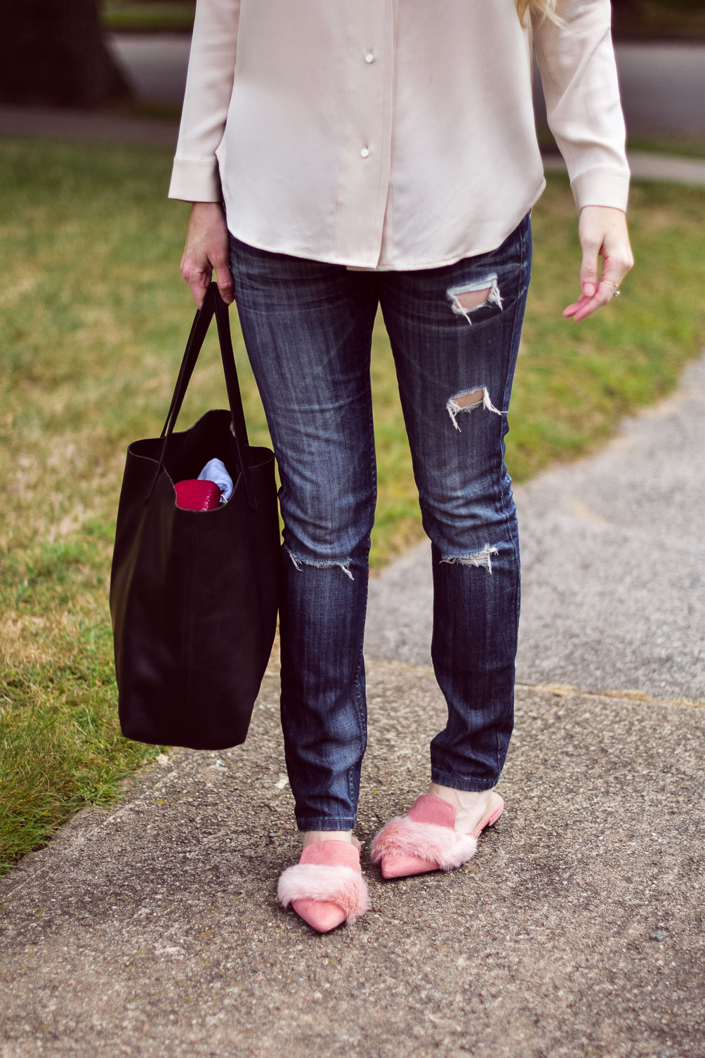Leslie Musser styling pink fur loafers for fall with distressed skinny jeans, a blush silk top, and black leather tote