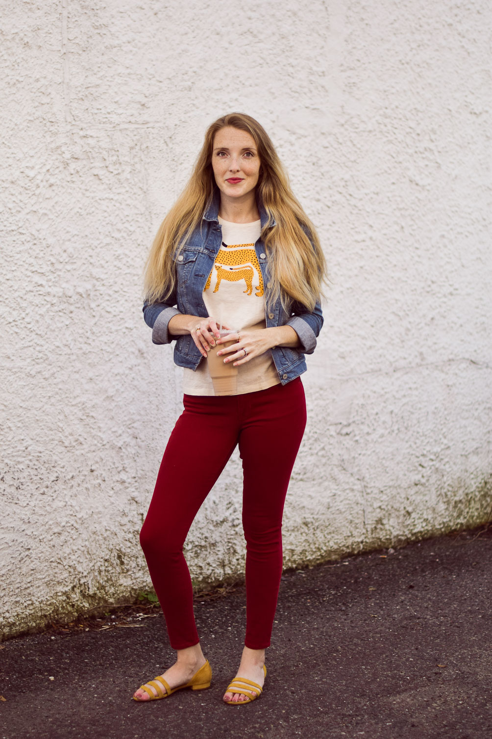 styling red skinny jeans for fall with a denim jacket and citron graphic tee