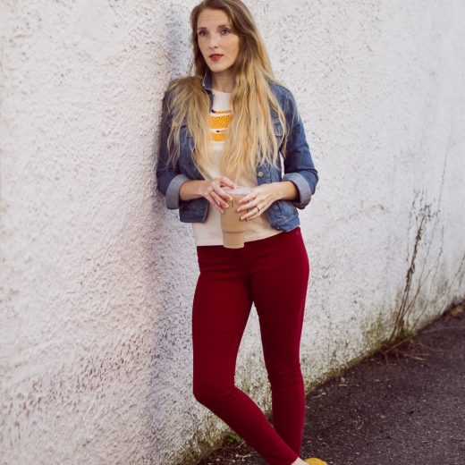 styling red skinny jeans for fall with a denim jacket and citron graphic tee