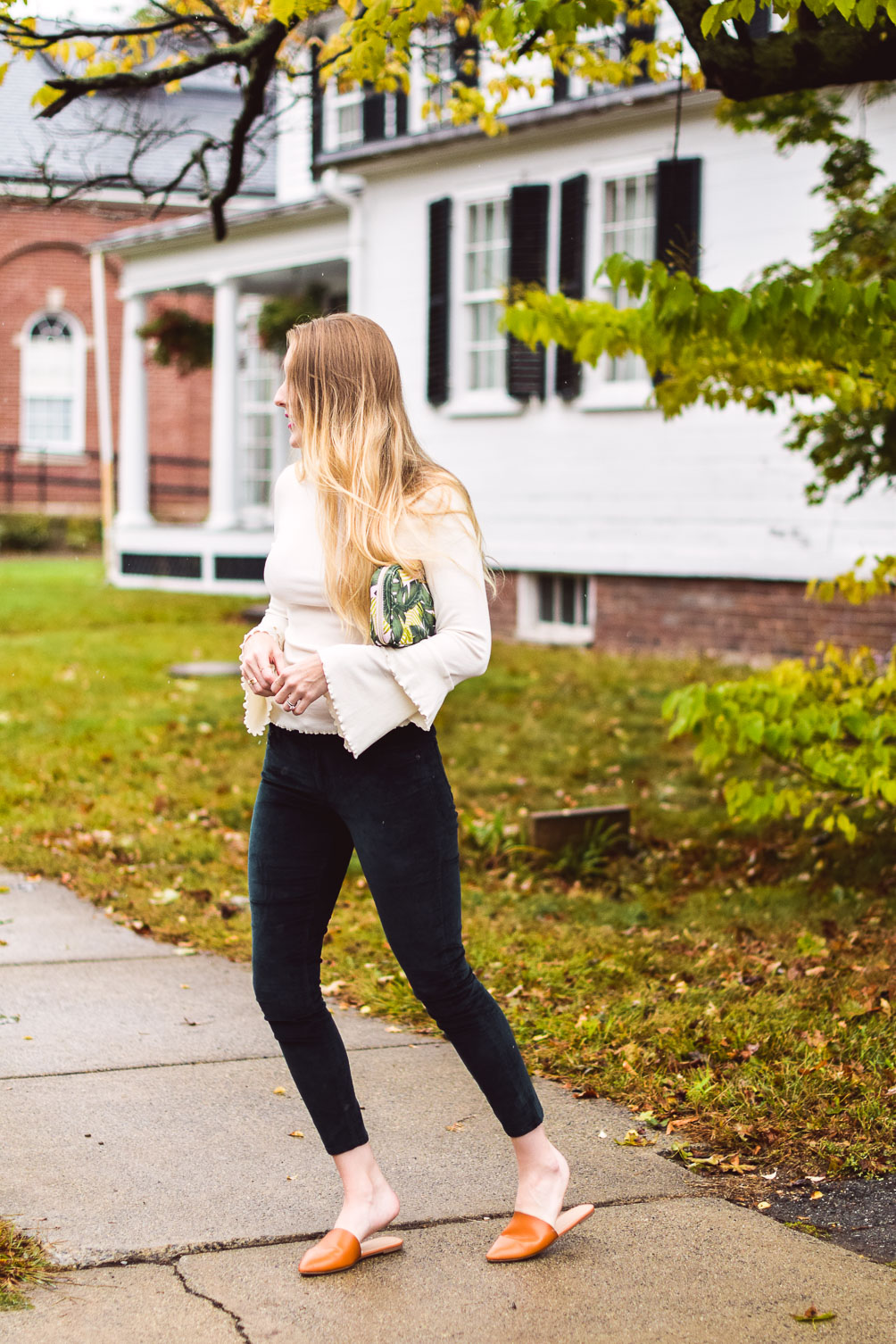styling deep green velvet pants with a ruffled bell sleeve sweater and faux leather slides for top fall fashion trends