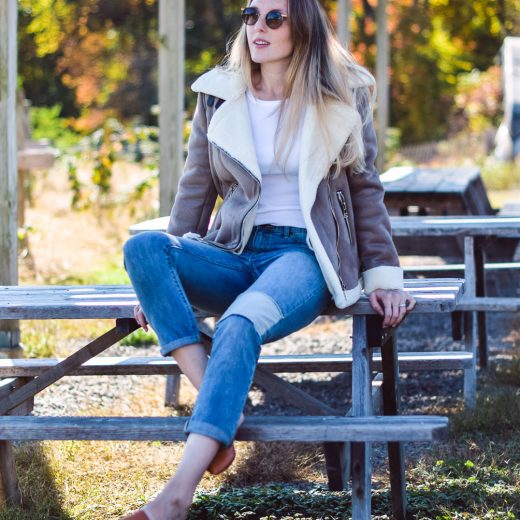 styling this faux suede moto jacket for fall and winter with a white henley, patched boyfriend jeans, and tan slides