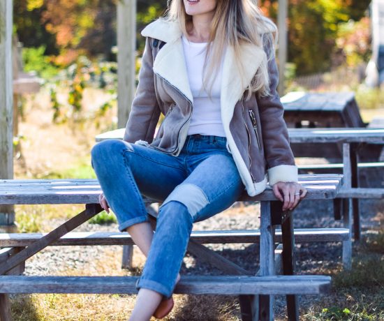 styling this faux suede moto jacket for fall and winter with a white henley, patched boyfriend jeans, and tan slides