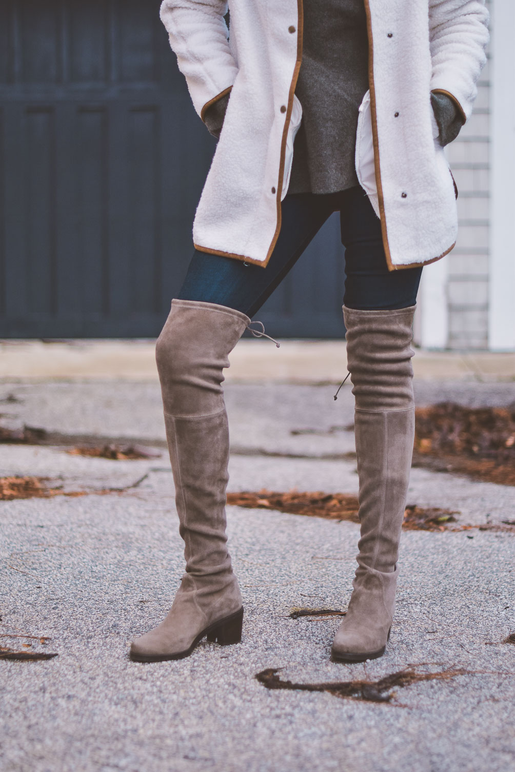 wearing a faux white sherpa jacket for styling neutrals with this cashmere sweater and over the knee Stuart Weitzman boots