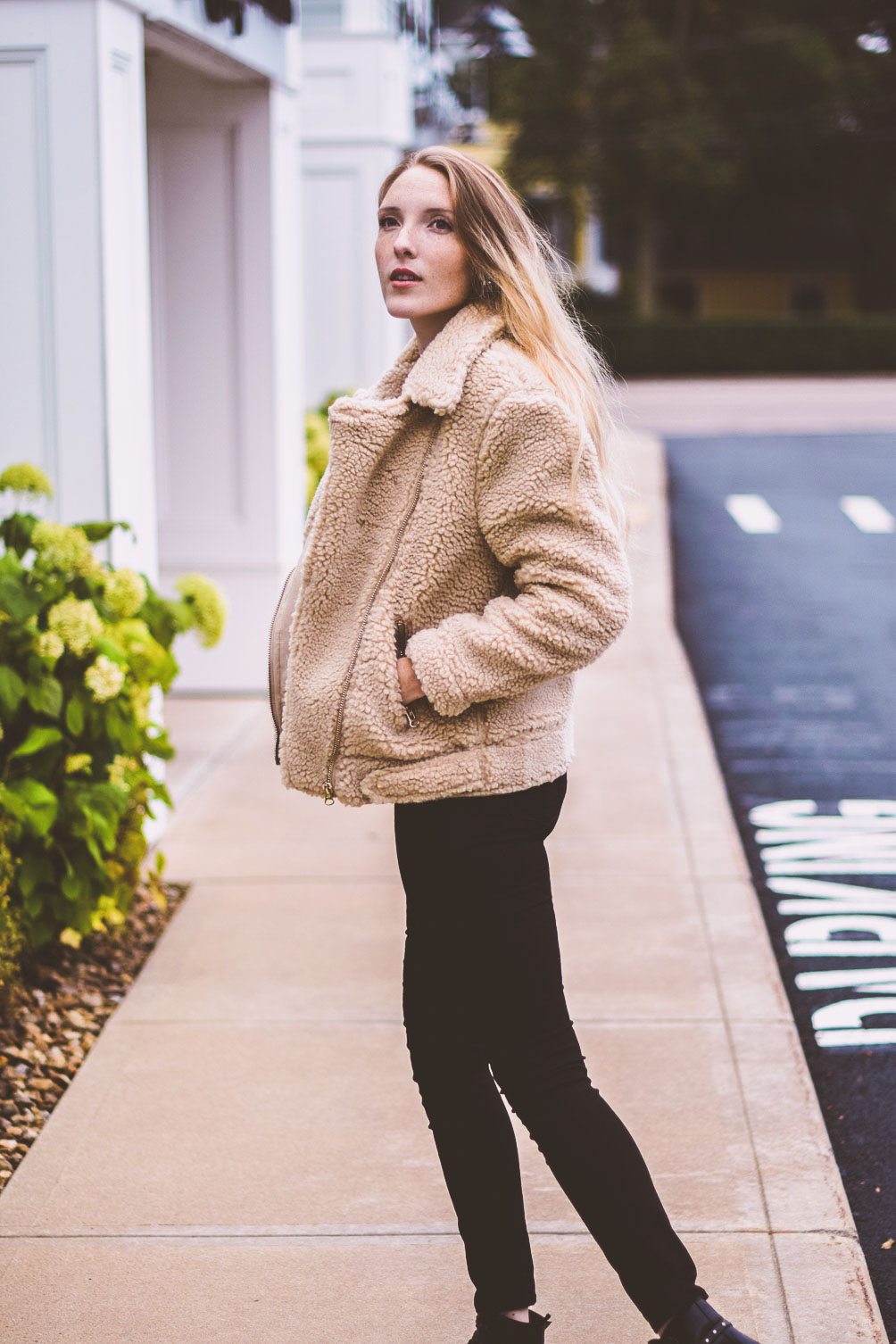 styling a teddy bear jacket as the best outerwear option for winter with a striped top and black skinny jeans