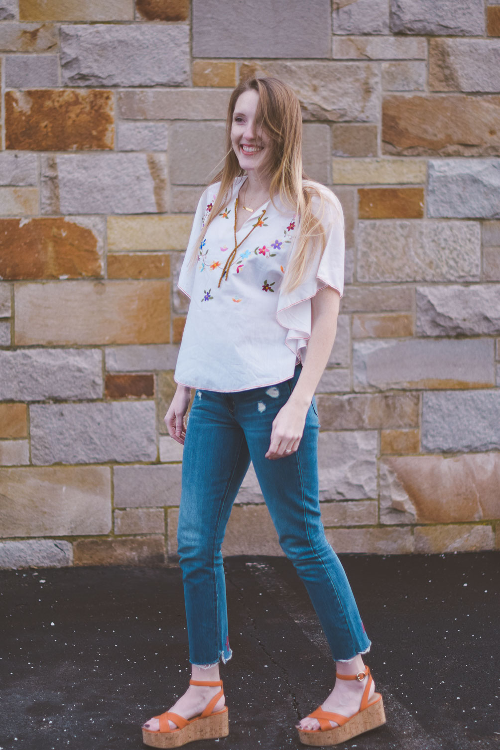 wearing an embroidered vintage top for spring with raw edge denim and cork platform sandals