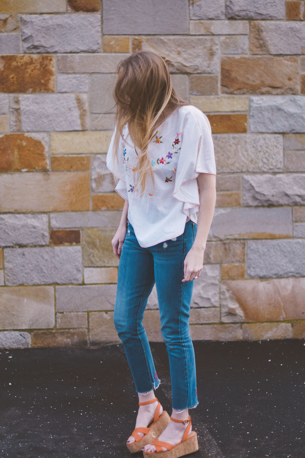 wearing an embroidered vintage top for spring with raw edge denim and cork platform sandals