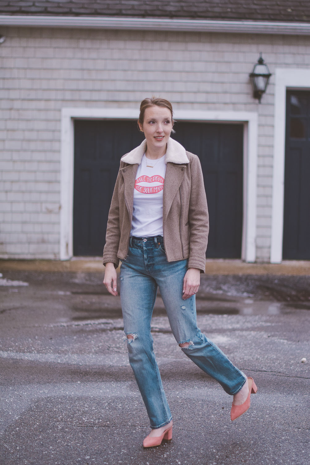 wearing Gap x Cone Denim high rise straight jeans with a shearling collar jacket, graphic tee, and pink block heel mules
