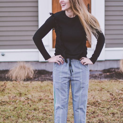 styling a modern checked track pant for everyday wear with black leather mules and a fringe sweater