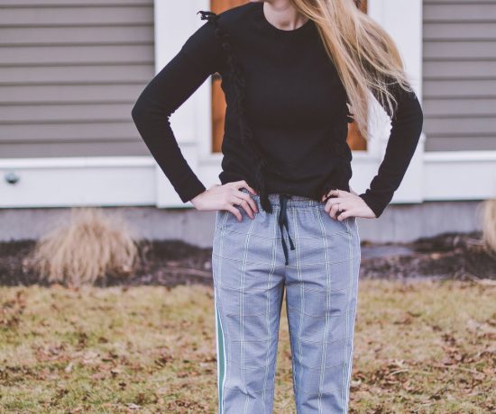 styling a modern checked track pant for everyday wear with black leather mules and a fringe sweater