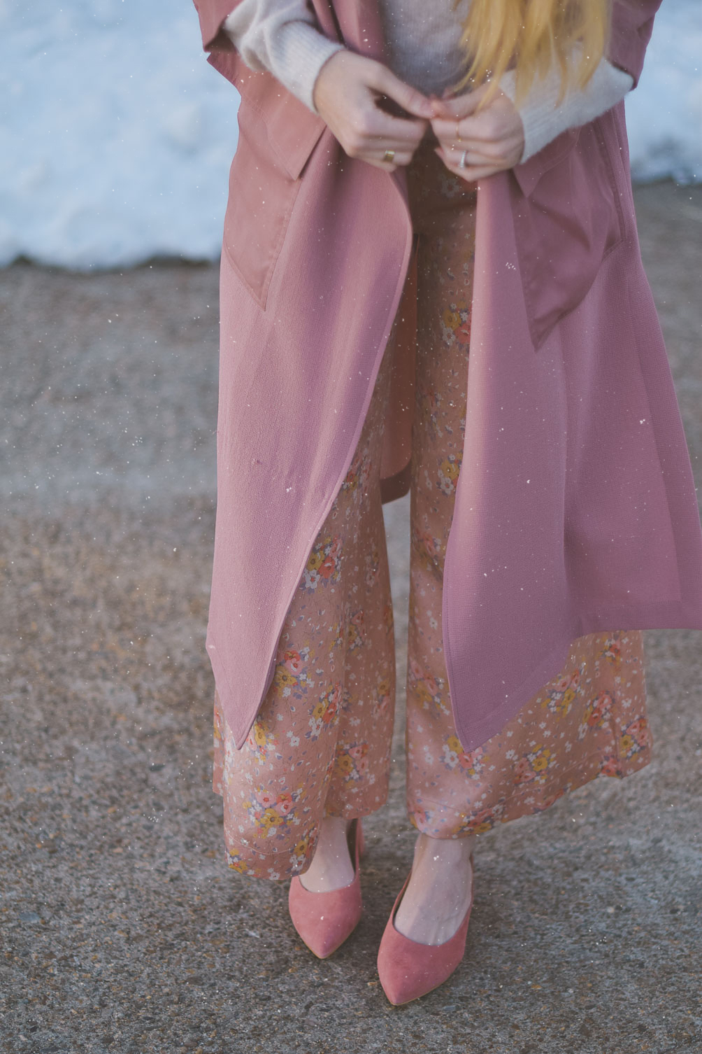 styling pastel pink for spring with a lightweight trench, appliqué sweater, silk trousers, and suede mules