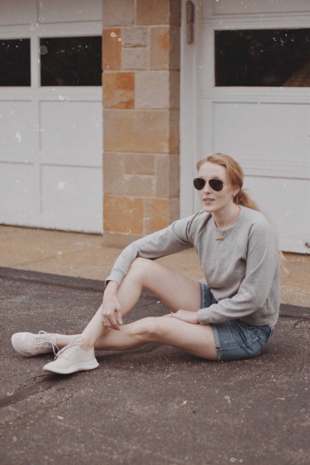styling an easy casual summer outfit idea with sustainable fashion brands Everlane crewneck sweatshirt, Allbirds sneakers, cutoff shorts