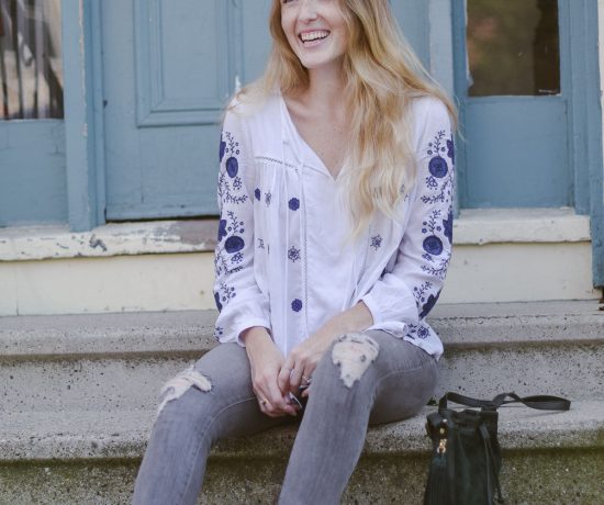 fashion blogger Leslie Musser styling the best bohemian tops for fall with gray denim, printed loafers, and a suede bucket bag